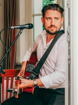 Ryan Inglis playing guitar at a wedding reception